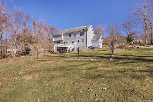 back of property with stairs, a yard, a deck, and fence