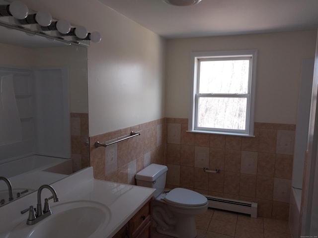 bathroom featuring tile walls, toilet, a baseboard heating unit, vanity, and tile patterned floors