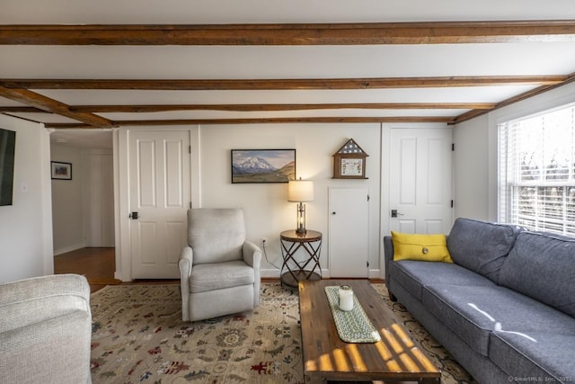 living room featuring beamed ceiling, wood finished floors, and baseboards