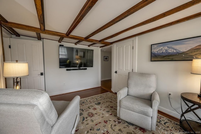 living area with wood finished floors, beam ceiling, and baseboards