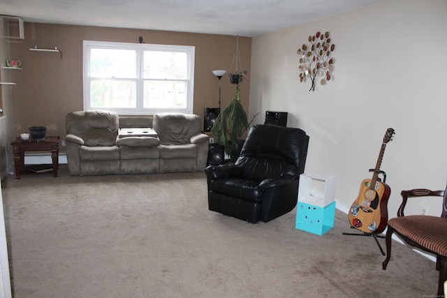 living area with carpet floors, a baseboard heating unit, and a wall mounted air conditioner