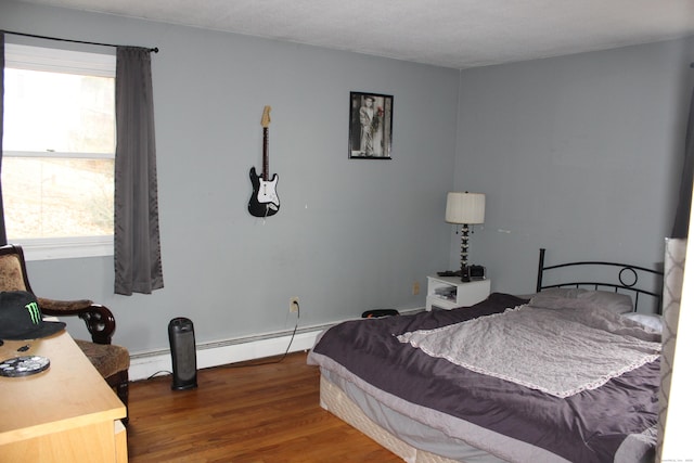 bedroom featuring a baseboard radiator and wood finished floors