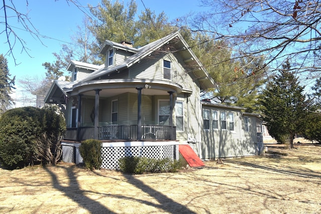 view of front of home featuring covered porch and a chimney