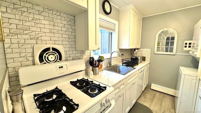 kitchen featuring tasteful backsplash, white cabinets, a sink, washer / dryer, and white range with gas stovetop