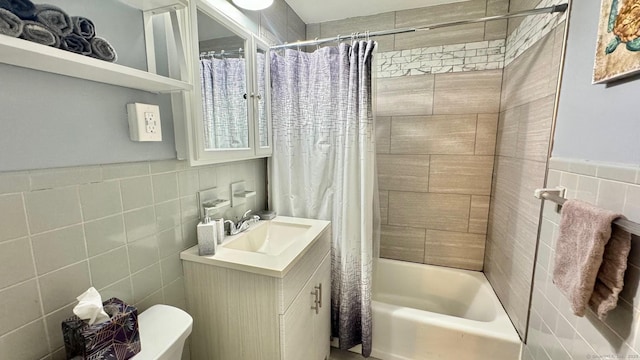 full bathroom featuring vanity, shower / bath combo with shower curtain, and tile walls