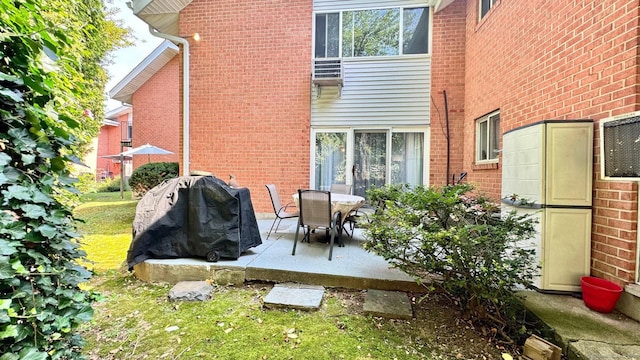 rear view of property with a patio and brick siding