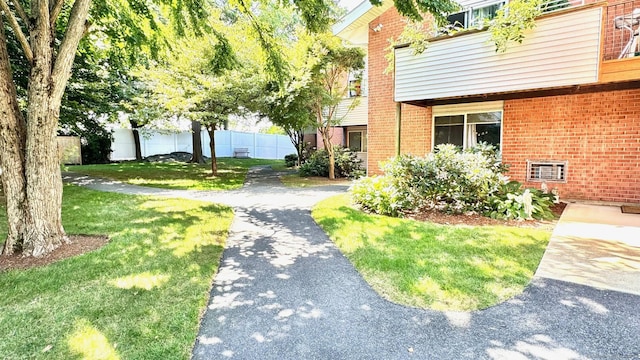 exterior space with a yard, fence, and driveway