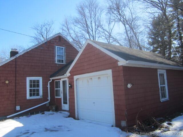 view of front of home featuring a shingled roof and a chimney