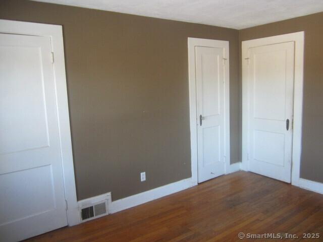 242 Elm St, Enfield, CT 06082 - unfurnished bedroom featuring baseboards and dark wood-style flooring