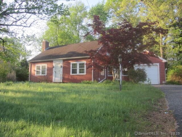 242 Elm St, Enfield, CT 06082 - view of front facade with a chimney, a garage, and driveway