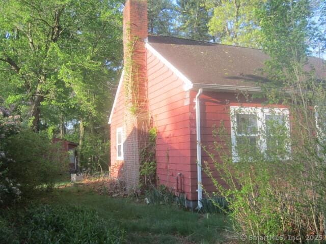 242 Elm St, Enfield, CT 06082 - view of home's exterior with a chimney