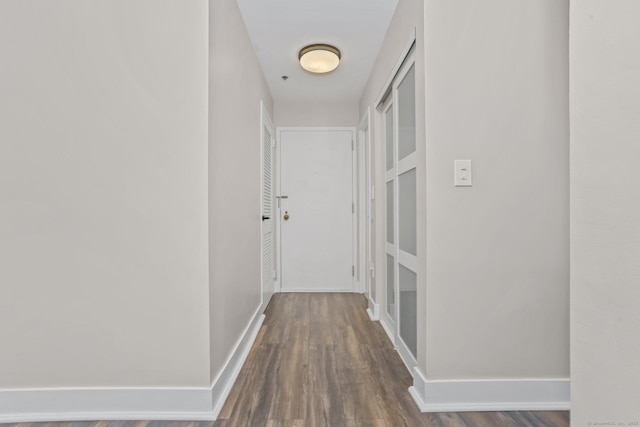 hall with baseboards and wood finished floors