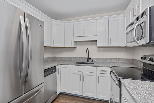 kitchen with appliances with stainless steel finishes, dark wood finished floors, white cabinets, and a sink