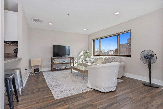 living area with baseboards, visible vents, dark wood finished floors, and recessed lighting