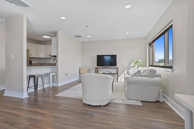 living area featuring dark wood-style floors, recessed lighting, visible vents, and baseboards