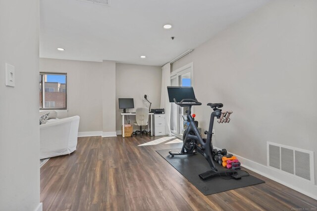 exercise room with baseboards, visible vents, wood finished floors, and recessed lighting