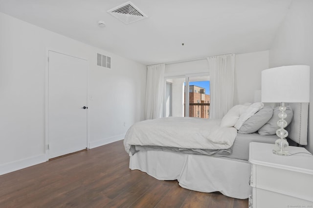 bedroom with dark wood-style floors, visible vents, and baseboards