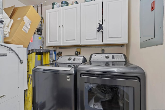 clothes washing area with electric panel, cabinet space, and washer and clothes dryer