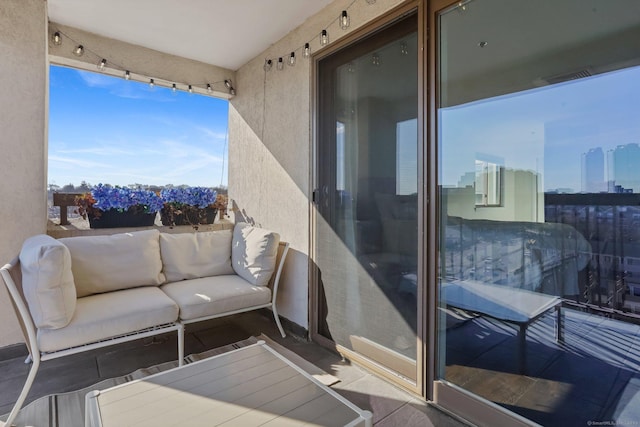 balcony with a view of city, visible vents, and an outdoor living space