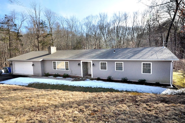 single story home featuring a garage, driveway, a chimney, and a front yard