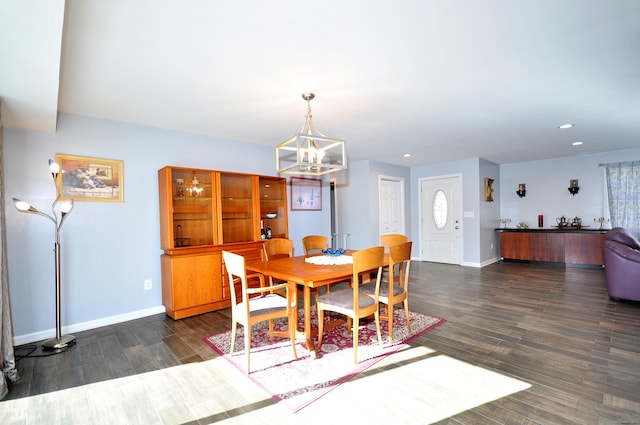 dining room with a notable chandelier, dark wood-type flooring, recessed lighting, and baseboards