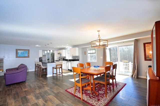 dining space with dark wood-style floors, recessed lighting, a chandelier, and baseboards