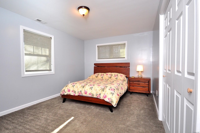 carpeted bedroom featuring a closet, visible vents, and baseboards