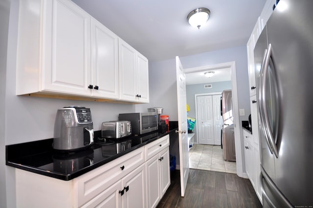 kitchen with visible vents, dark countertops, appliances with stainless steel finishes, dark wood-type flooring, and white cabinetry