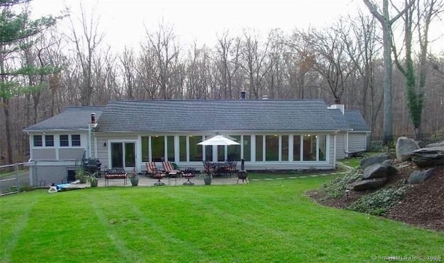 rear view of house with a yard and a patio