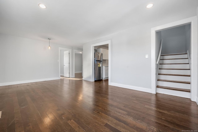 unfurnished living room featuring baseboards, stairway, dark wood-type flooring, and recessed lighting