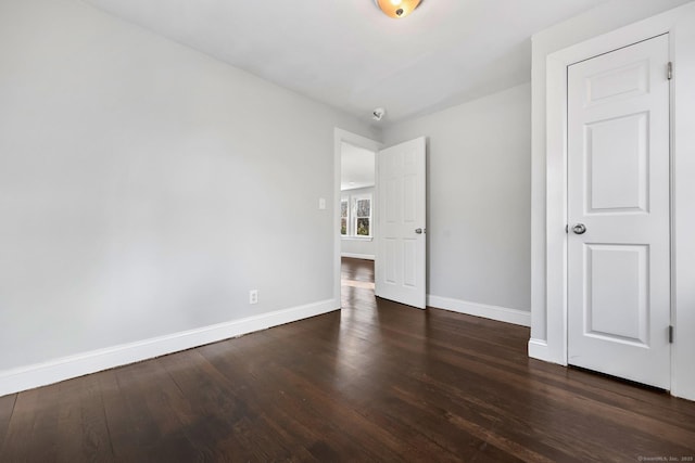 unfurnished bedroom with wood finished floors and baseboards