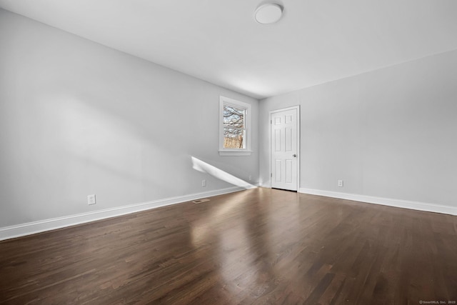 spare room with wood finished floors and baseboards