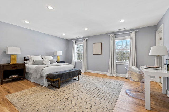 bedroom featuring light wood-style floors, baseboards, multiple windows, and visible vents