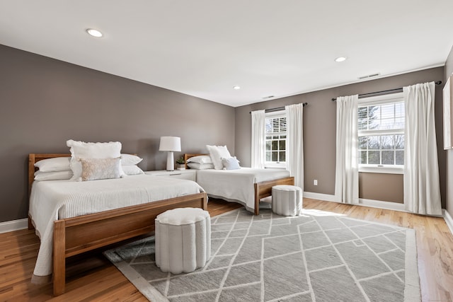 bedroom with baseboards, recessed lighting, visible vents, and light wood-style floors