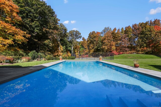 outdoor pool with a lawn and fence