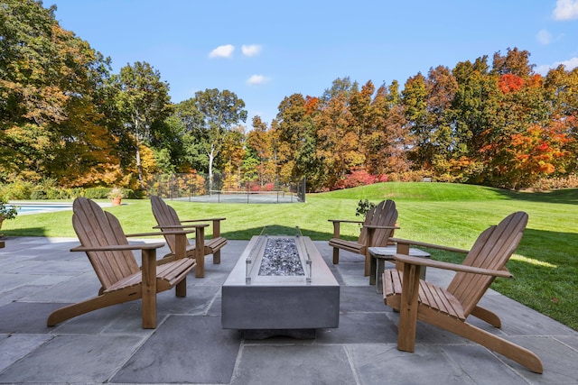 view of patio / terrace featuring a pool, fence, and a fire pit