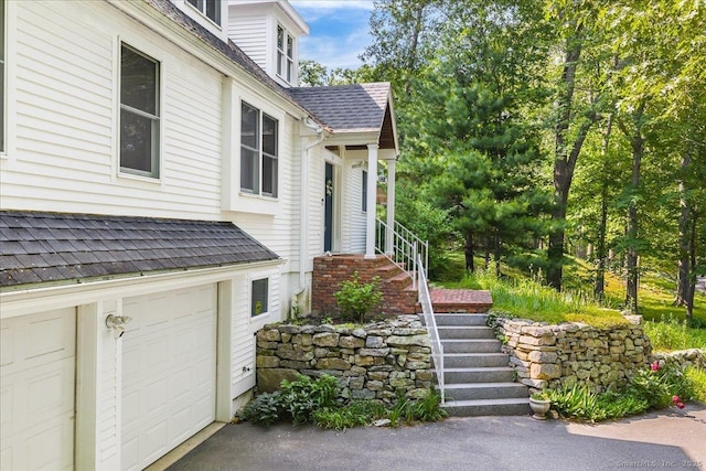 37 Skyline Dr, Groton, CT 06340 - doorway to property with an attached garage, a shingled roof, and driveway
