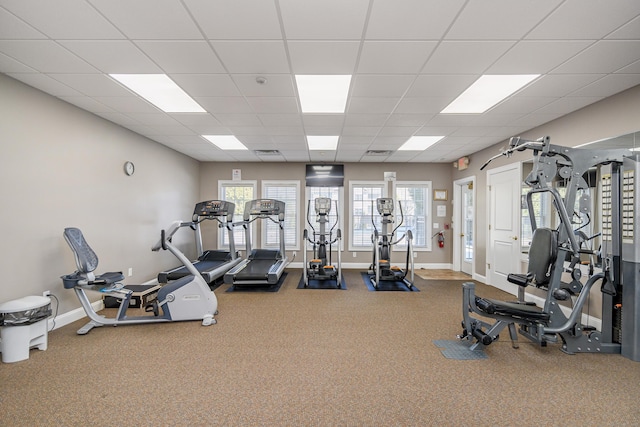 workout area featuring carpet flooring, a paneled ceiling, and baseboards