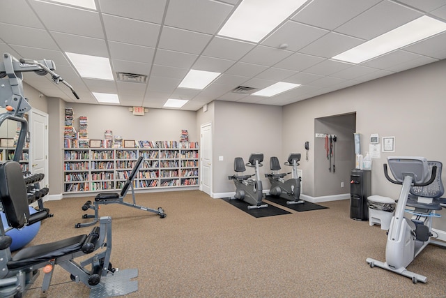 gym featuring a paneled ceiling, visible vents, and baseboards