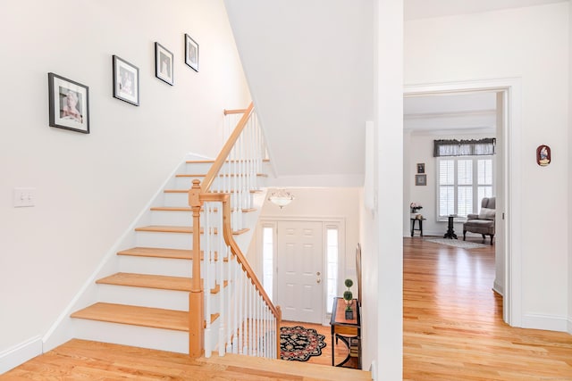 foyer featuring stairs, baseboards, and wood finished floors