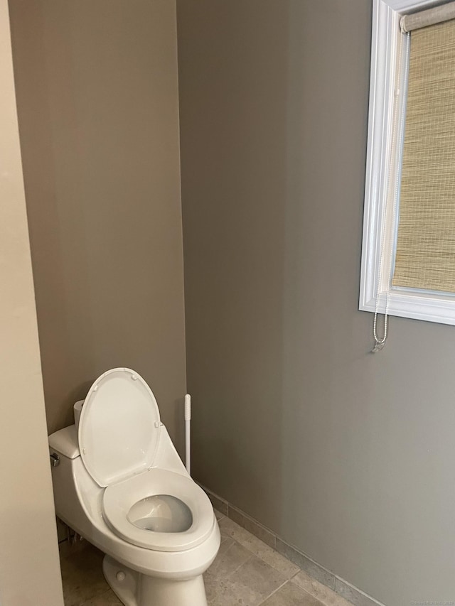 bathroom with toilet and baseboards