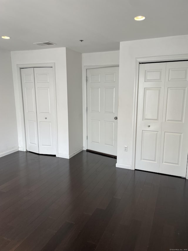 unfurnished bedroom featuring dark wood-style flooring, recessed lighting, a closet, and baseboards