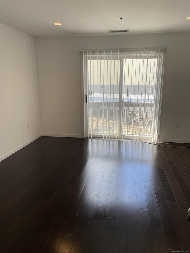 spare room featuring baseboards, visible vents, dark wood finished floors, and recessed lighting