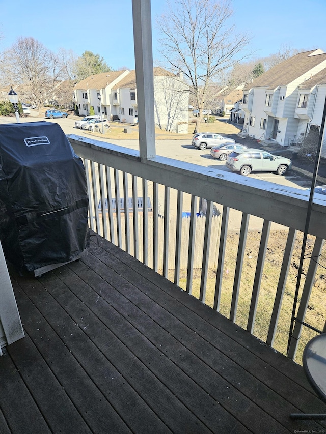 wooden deck featuring a residential view and a grill