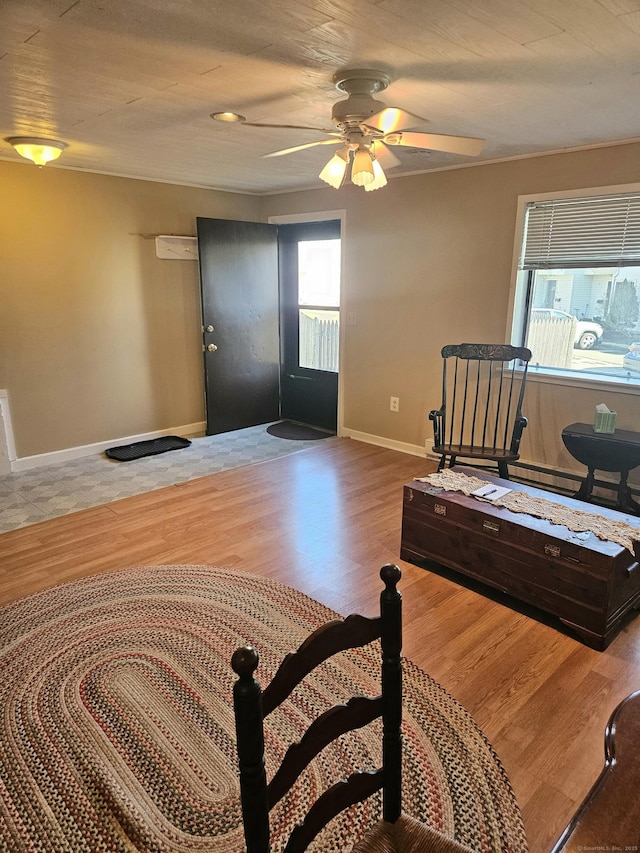 interior space featuring a ceiling fan, baseboards, and wood finished floors