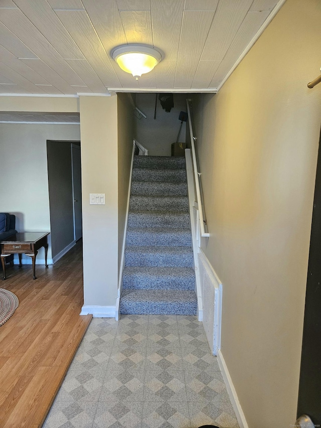 staircase featuring visible vents, baseboards, and wood finished floors