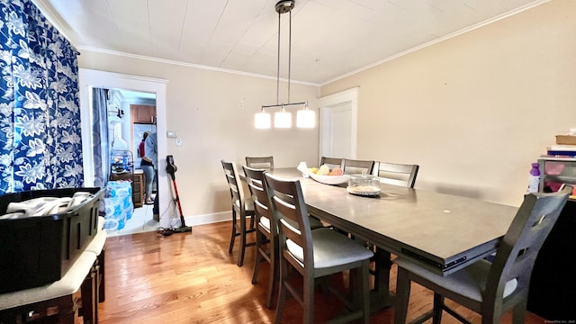 dining area featuring baseboards, crown molding, and wood finished floors