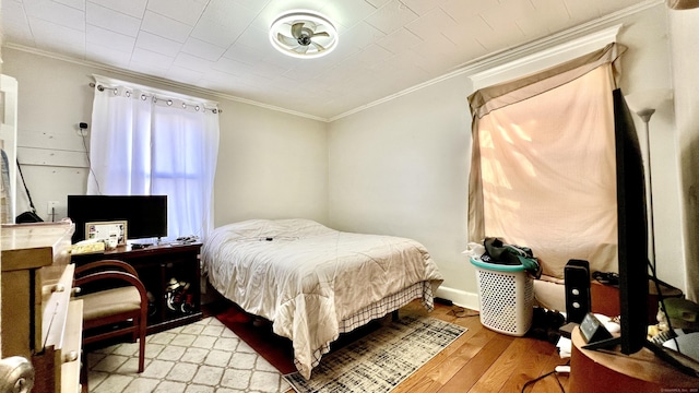 bedroom with ornamental molding, baseboards, and light wood finished floors