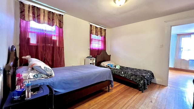 bedroom with hardwood / wood-style flooring and baseboards