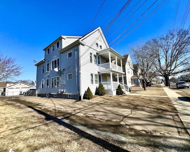 view of property exterior with covered porch and a balcony